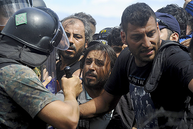 Сотрудники македонской полиции пытаются навести порядок на границе с Грецией, где скопились тысячи мигрантов.